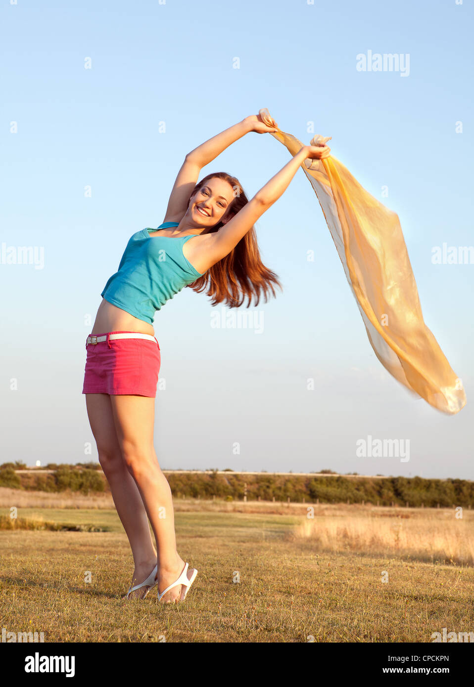 Sommerfoto einer jungen Frau, die ihr Kopftuch im Wind wehende Stockfoto