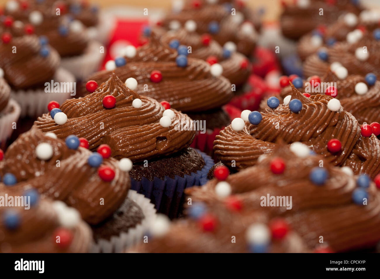 Schokolade verrohrt Vereisung mit Zucker Kugeln auf kleine Kuchen Stockfoto