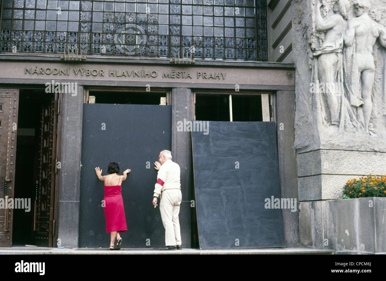 Frau und Mann halten Eingangstür Regierungsgebäude.  Prag - Tschechische Hauptstadt im letzten Jahrzehnt des kommunistischen Regimes. Foto im Jahr 1988. Jahr. Stockfoto