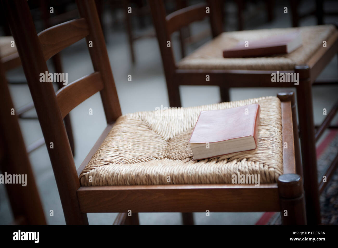 Bibel auf einfache Kirche Stuhl warten auf service Stockfoto