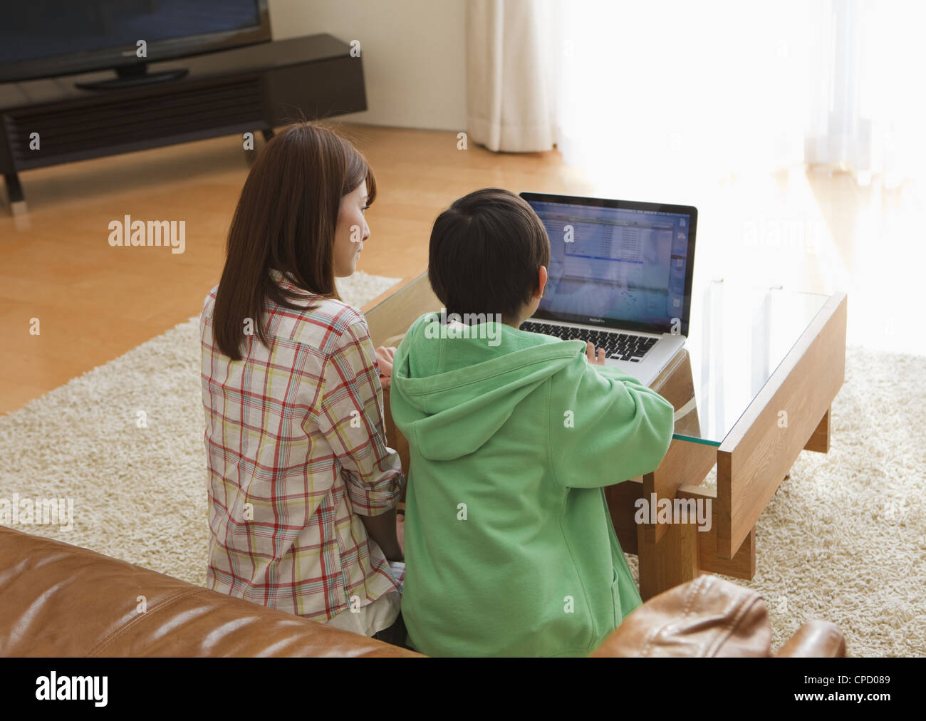 Mutter und Sohn Blick auf laptop Stockfoto