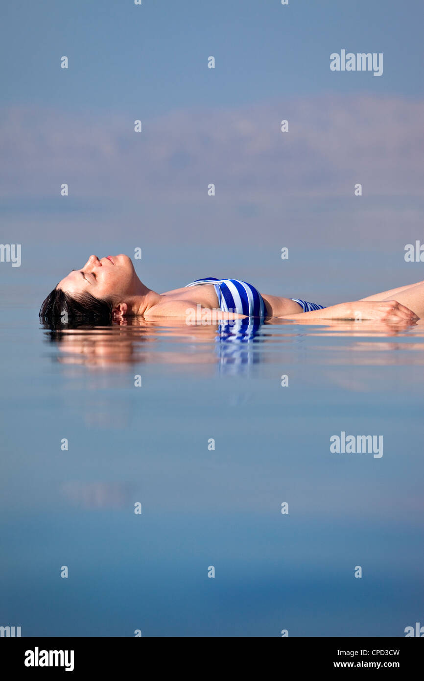 Junge Frau schwebt in das Tote Meer, Mövenpick Resort Hotel, Jordanien, Westasien Stockfoto