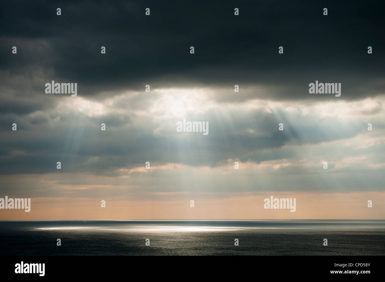 dämmerungsaktiv Sonnenstrahlen durch Brüche in den Wolken über dem Meer, UK Stockfoto