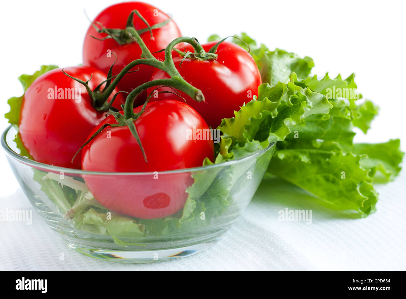 Der Zweig der ganzen roten Tomaten und Kopfsalat. Isoliert auf weiss Stockfoto