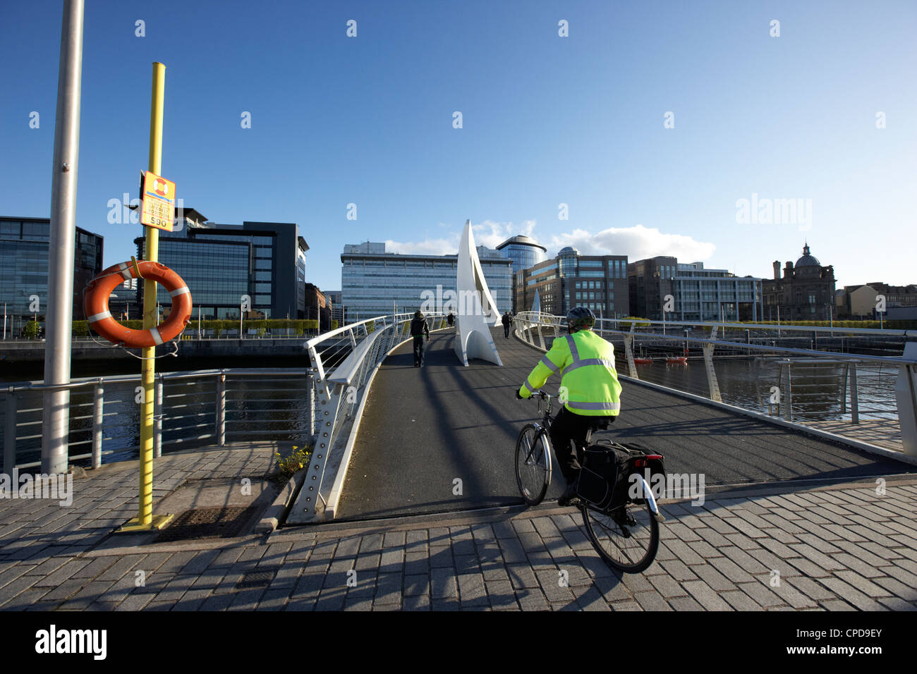 Pendler, Radfahren über die Tradeston Brücke Fußgängerbrücke über den Fluss Clyde in der finanziellen Bezirk von Glasgow Stockfoto