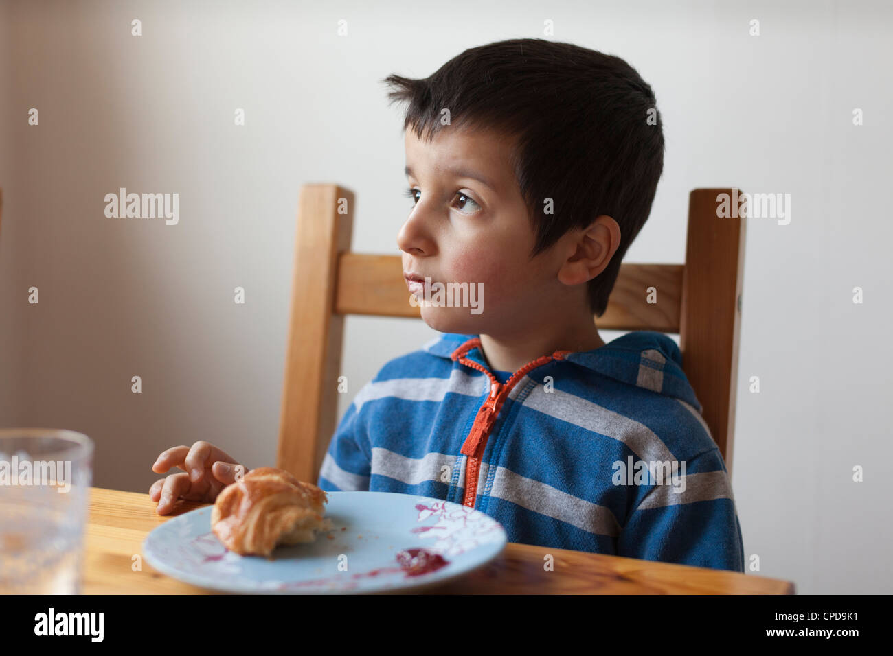 Nachdenklich 4 Jahre altes Kind, frühstücken Sie auf seine eigene Stockfoto