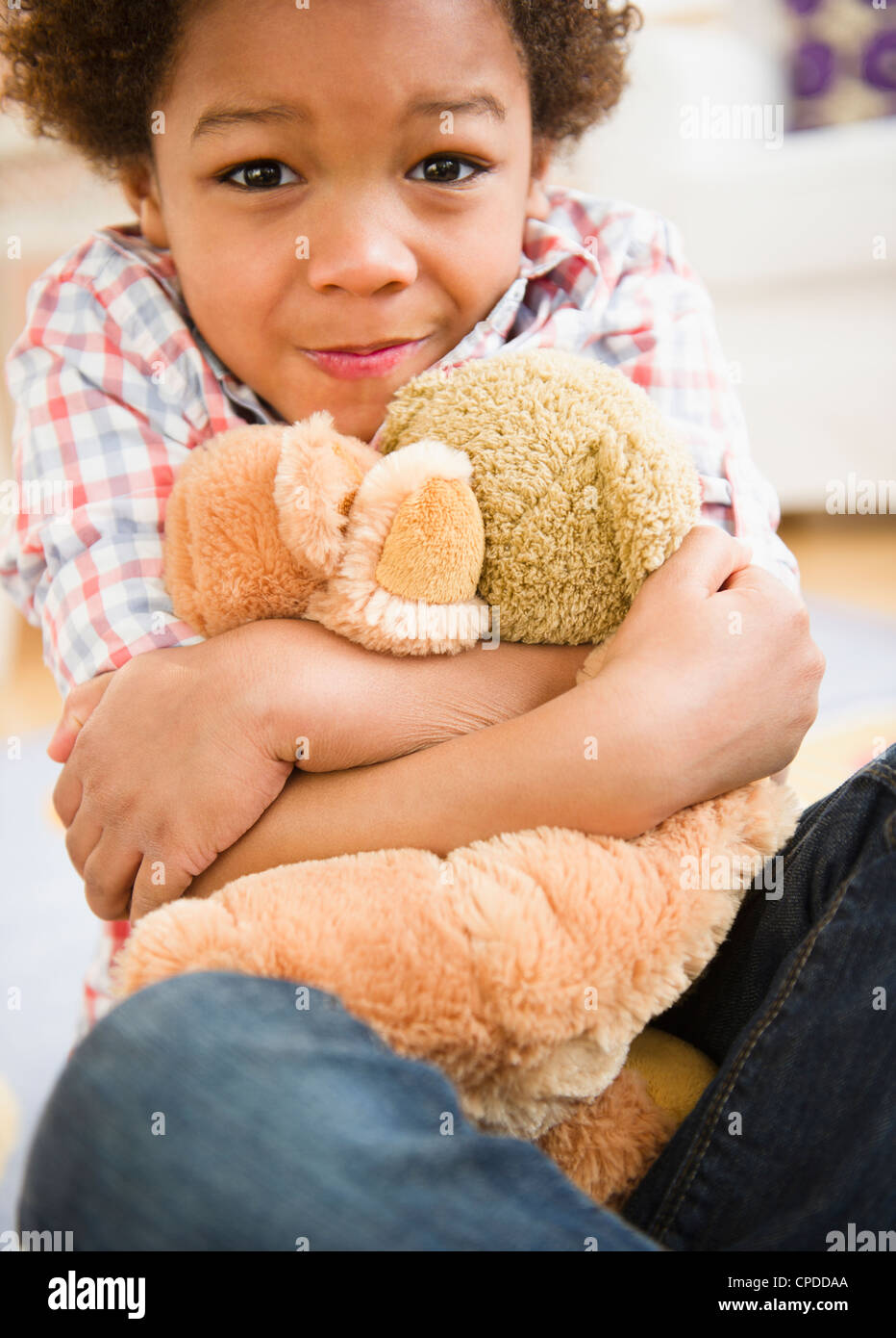 Schwarzer Junge umarmt Teddybär Stockfoto