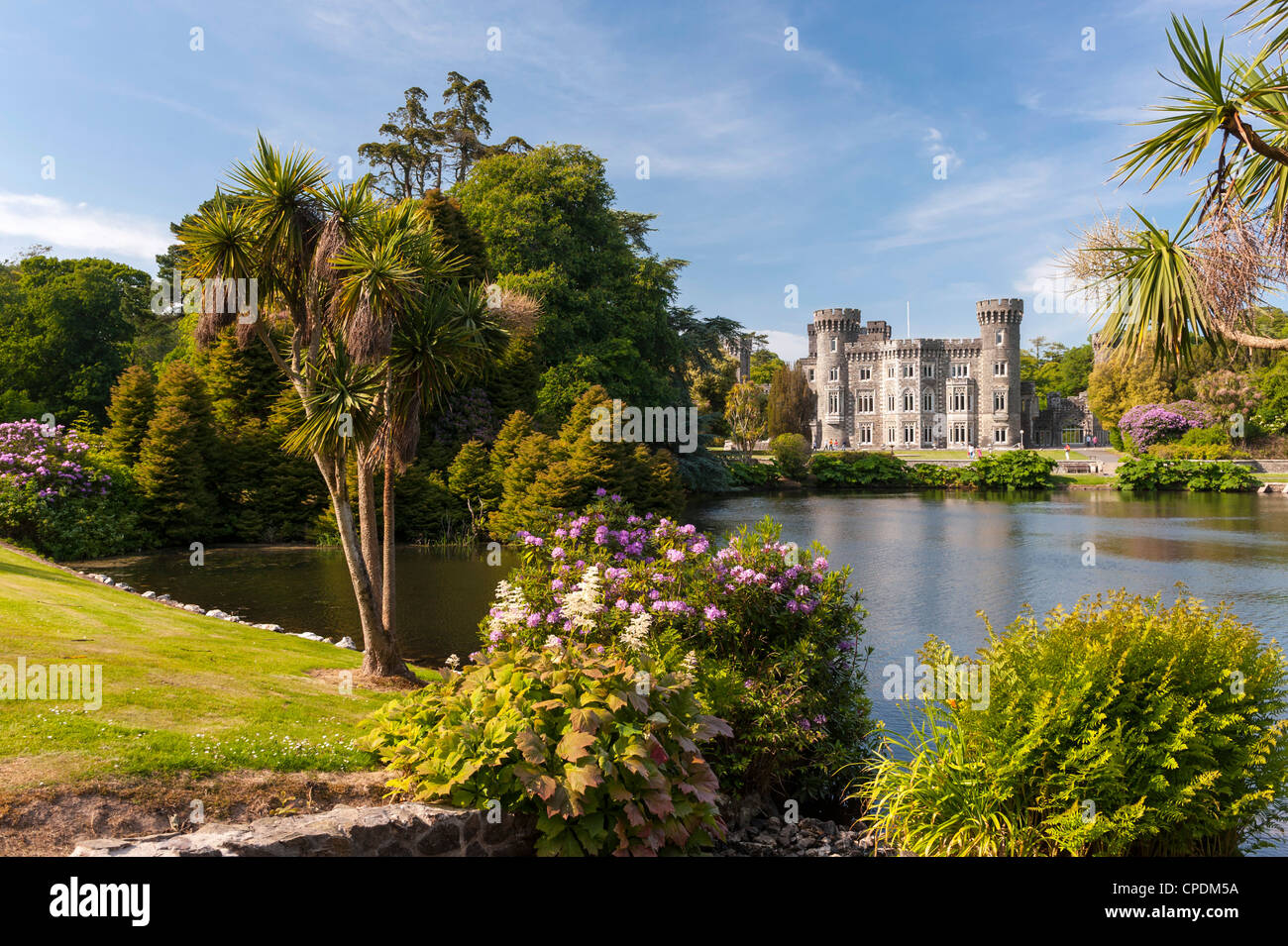 Historisches Irland - Blick über den See zum Johnstown Castle, einem wunderschönen irischen Haus, County Wexford im Frühjahr/Sommer Stockfoto