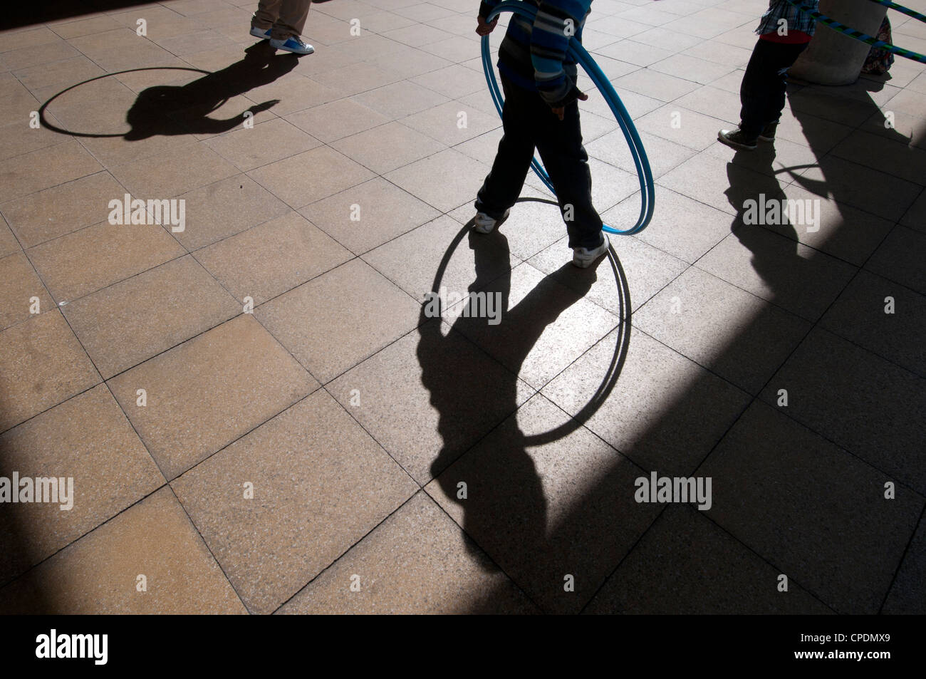 Hackney Central Library. Schatten der Kinder spielen mit Hula hoops Stockfoto