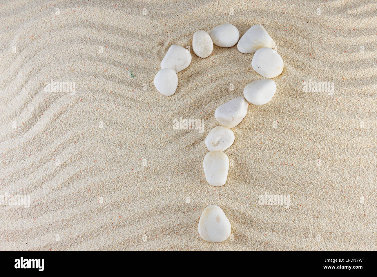 Fragezeichen aus Steinen mit Sand als Hintergrund Stockfoto