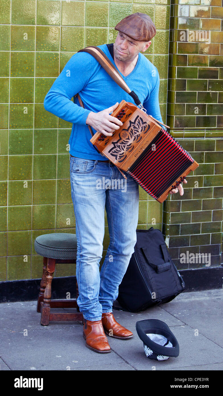 Porträt eines Straßenmusikers, der ein Akkordeon spielt, Columbia Road Flower Market, London, England, Großbritannien. Stockfoto