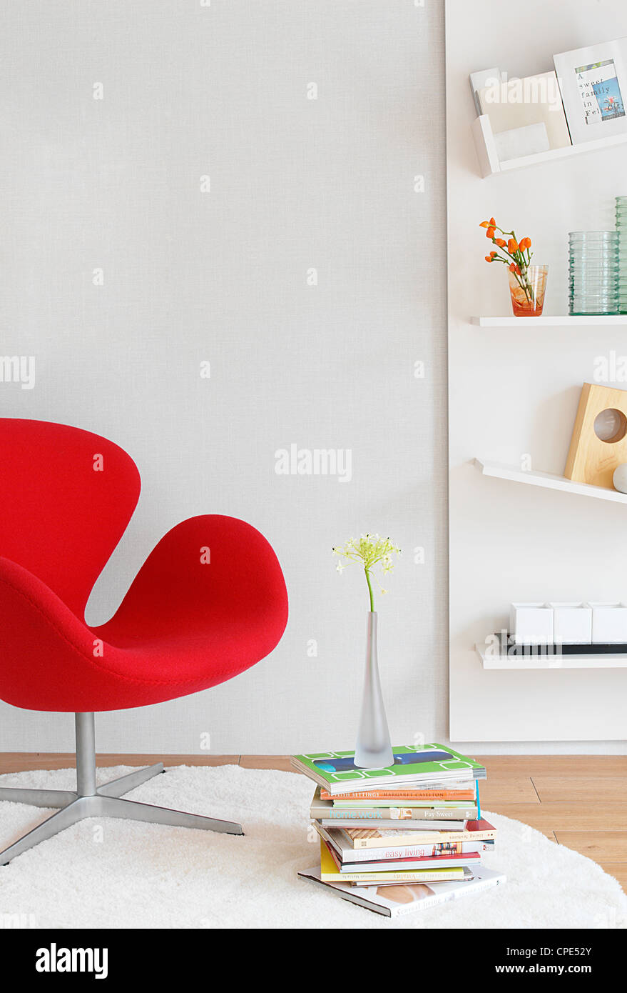 Moderne rote Sessel, Blumenvase auf Stack, Designer-Einrichtung, Zeichnung Zimmer buchen Stockfoto