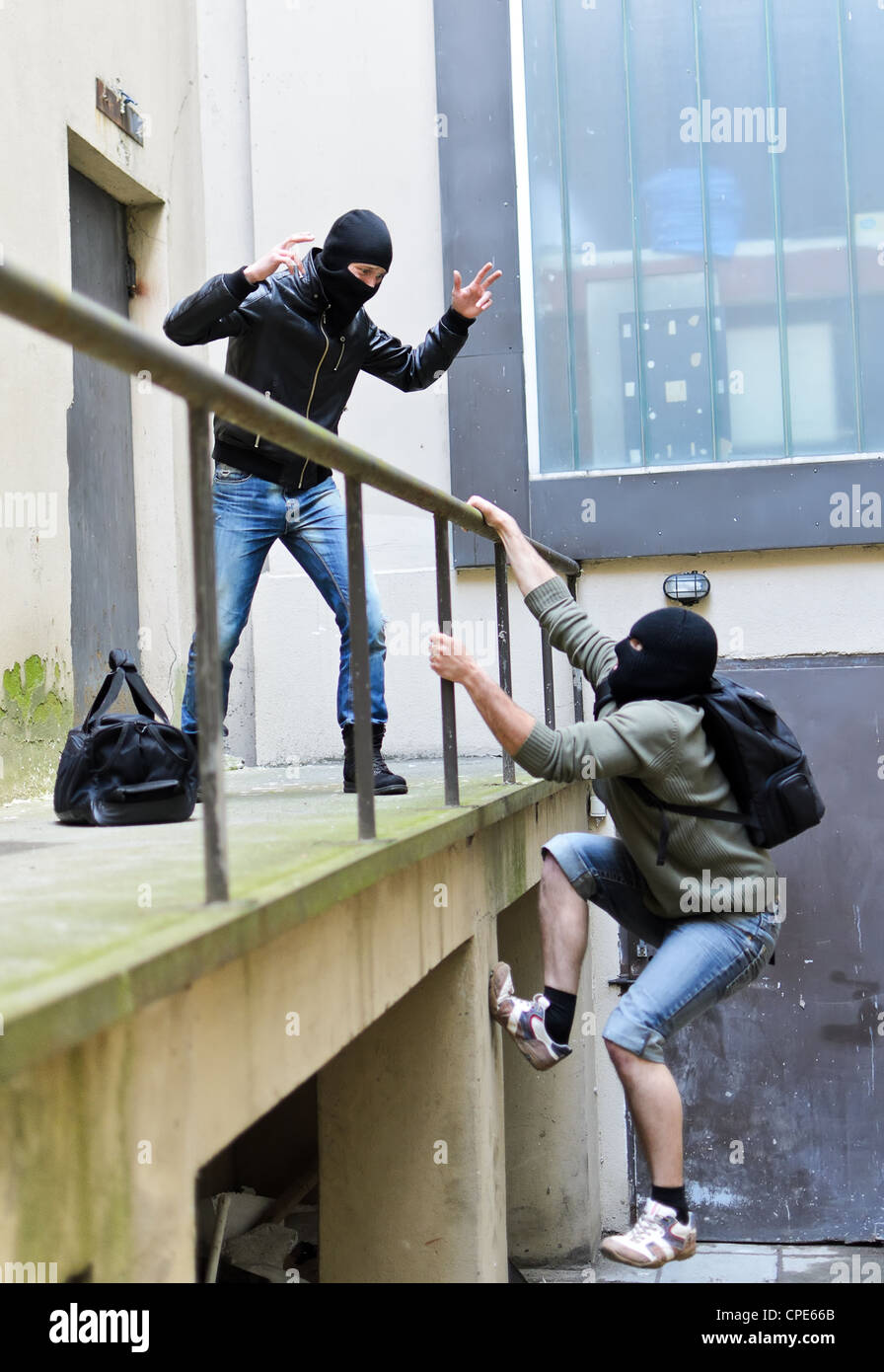 Flucht aus einem Raubüberfall. Man versucht zu helfen, die Schienen zu klettern. Stockfoto