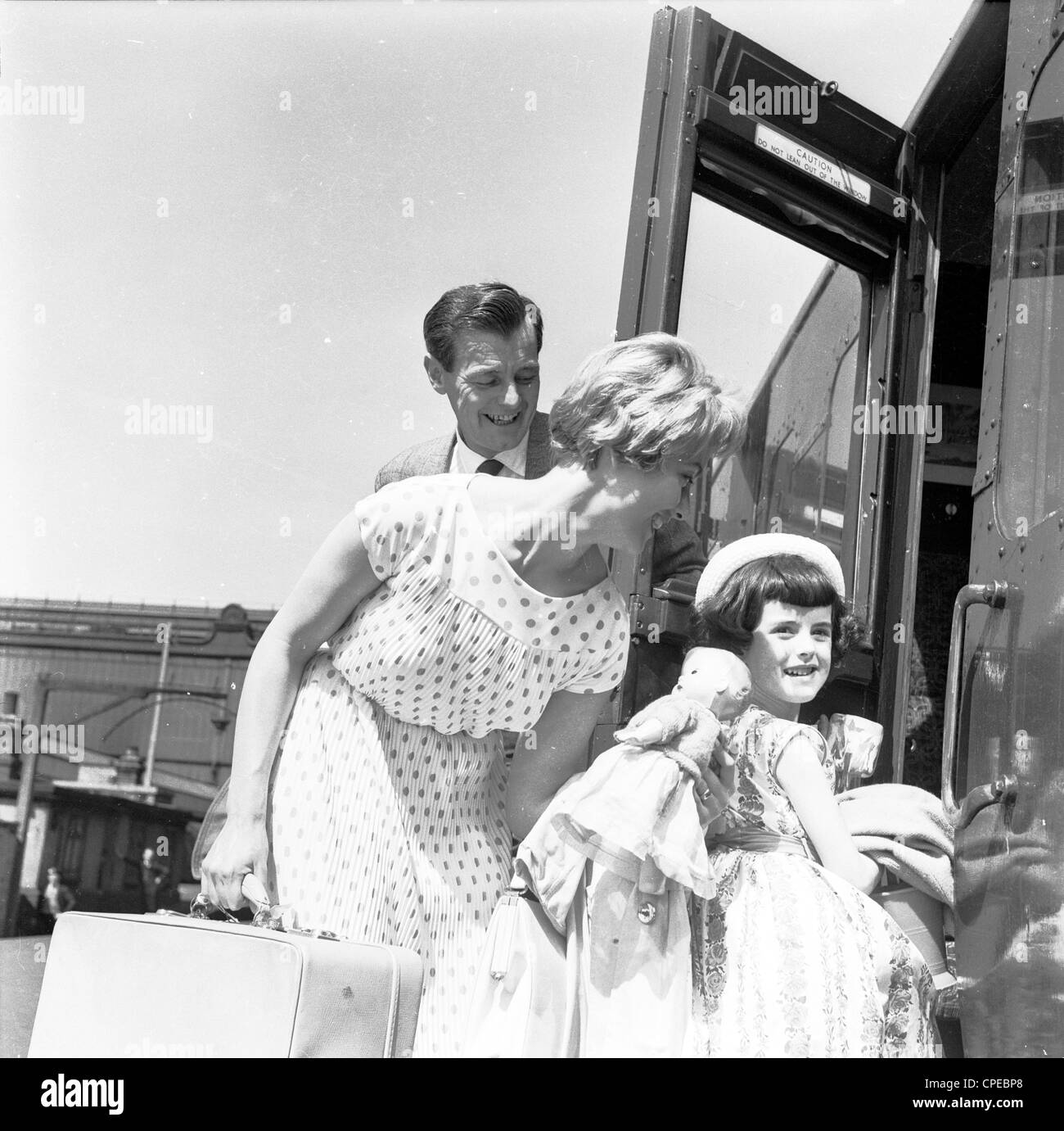 Der 1960er Jahre. Foto, Familie, Mann, Frau und Kind, mit Gepäck auf einem Bahnsteig an Bord eines Zuges. Stockfoto
