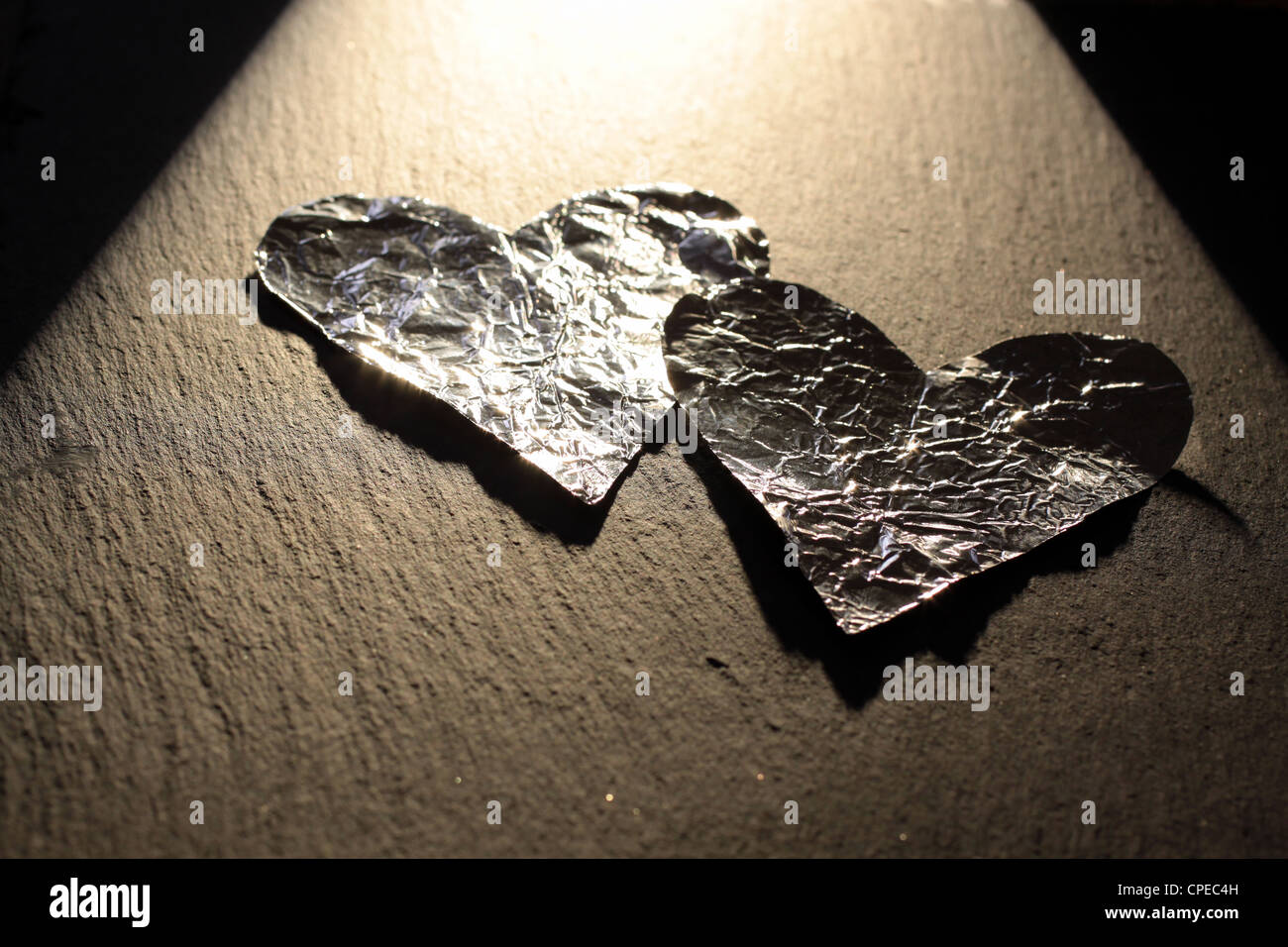 Zwei Aluminium-Herzen mit einem roten Glas Herzen Stockfoto