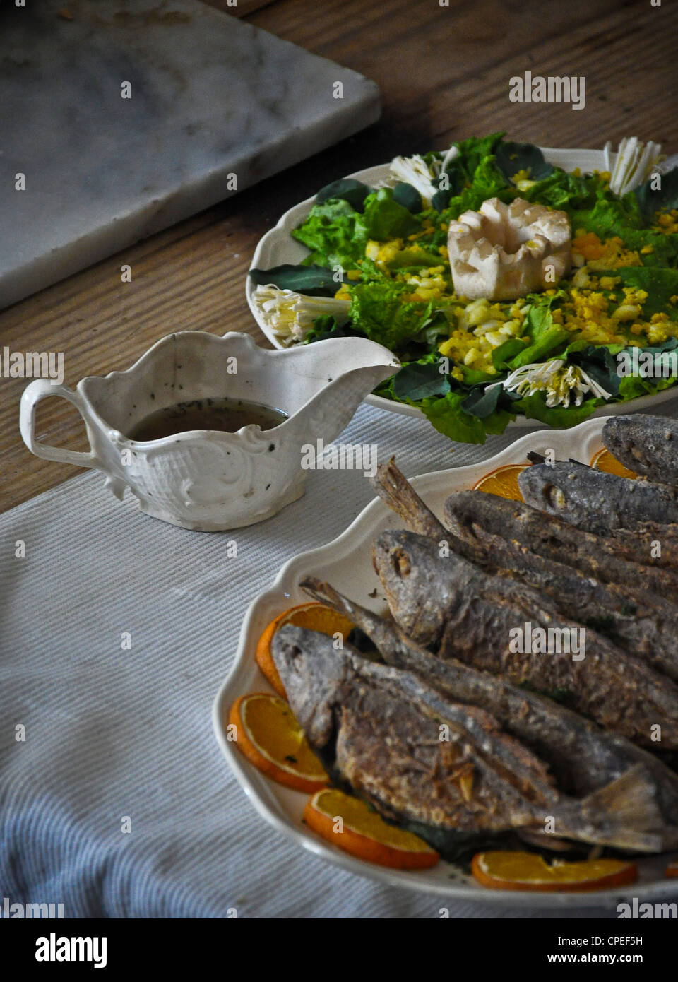 Esstisch, Fischplatte und Salat. Stockfoto