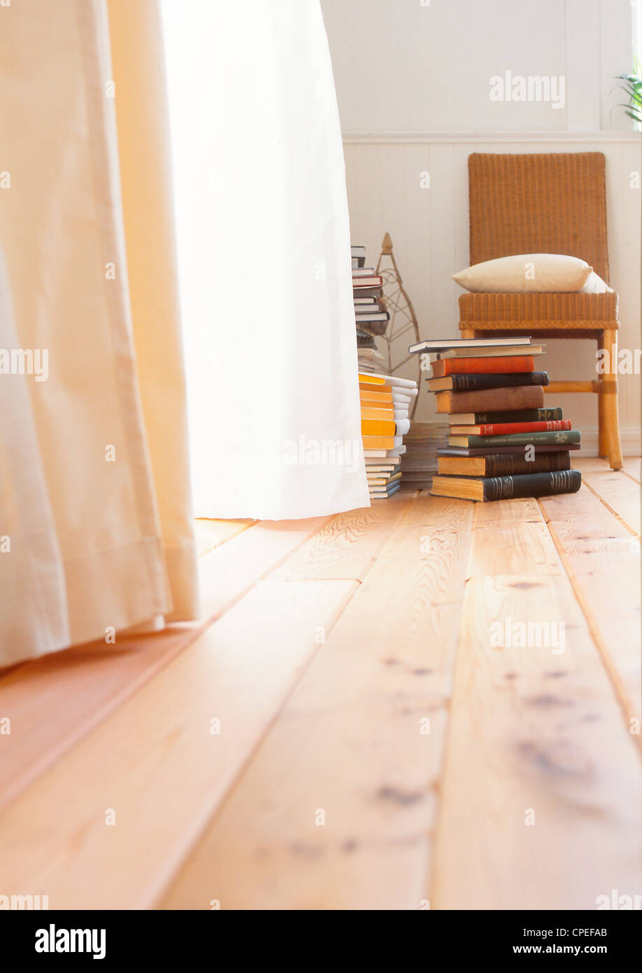 Stapel von Büchern und Stuhl In der Ecke des Raumes Stockfoto
