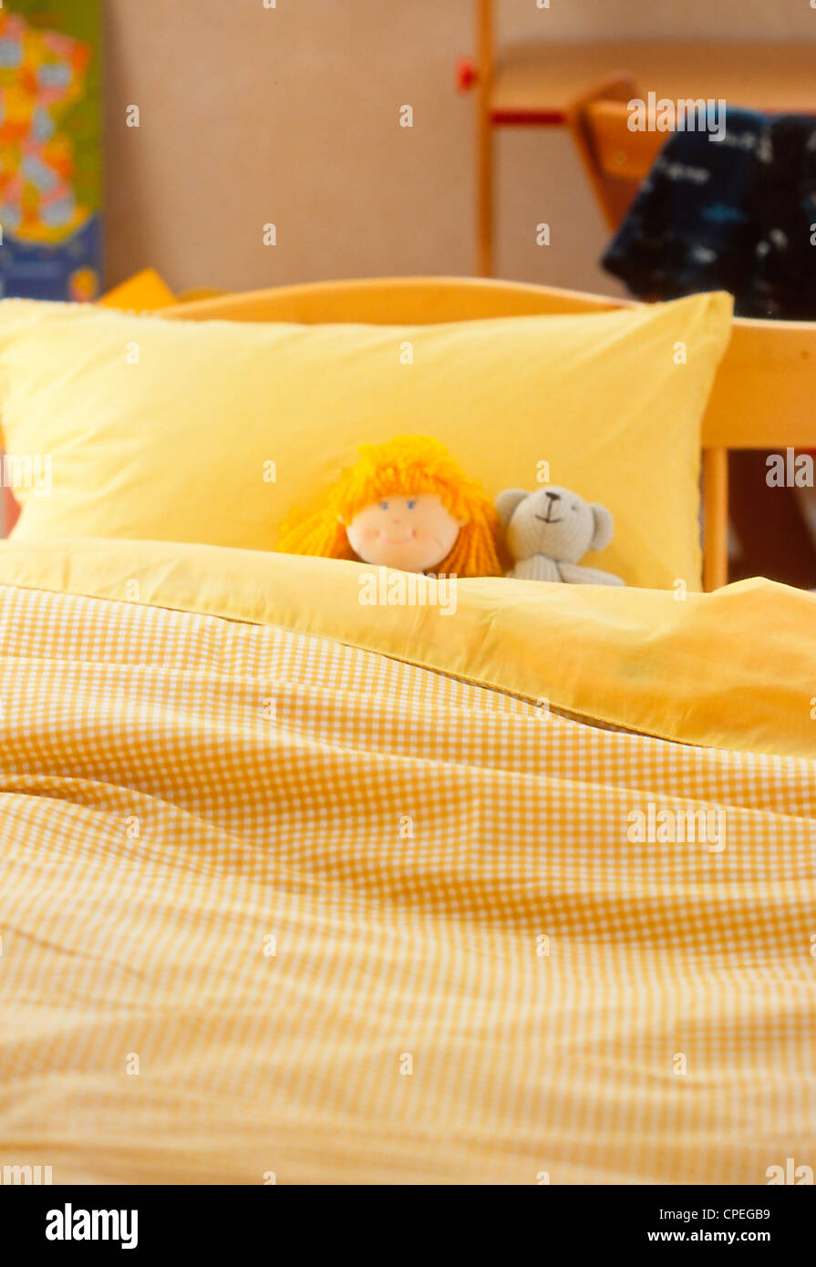 Teddy und Puppe auf Bett Stockfoto