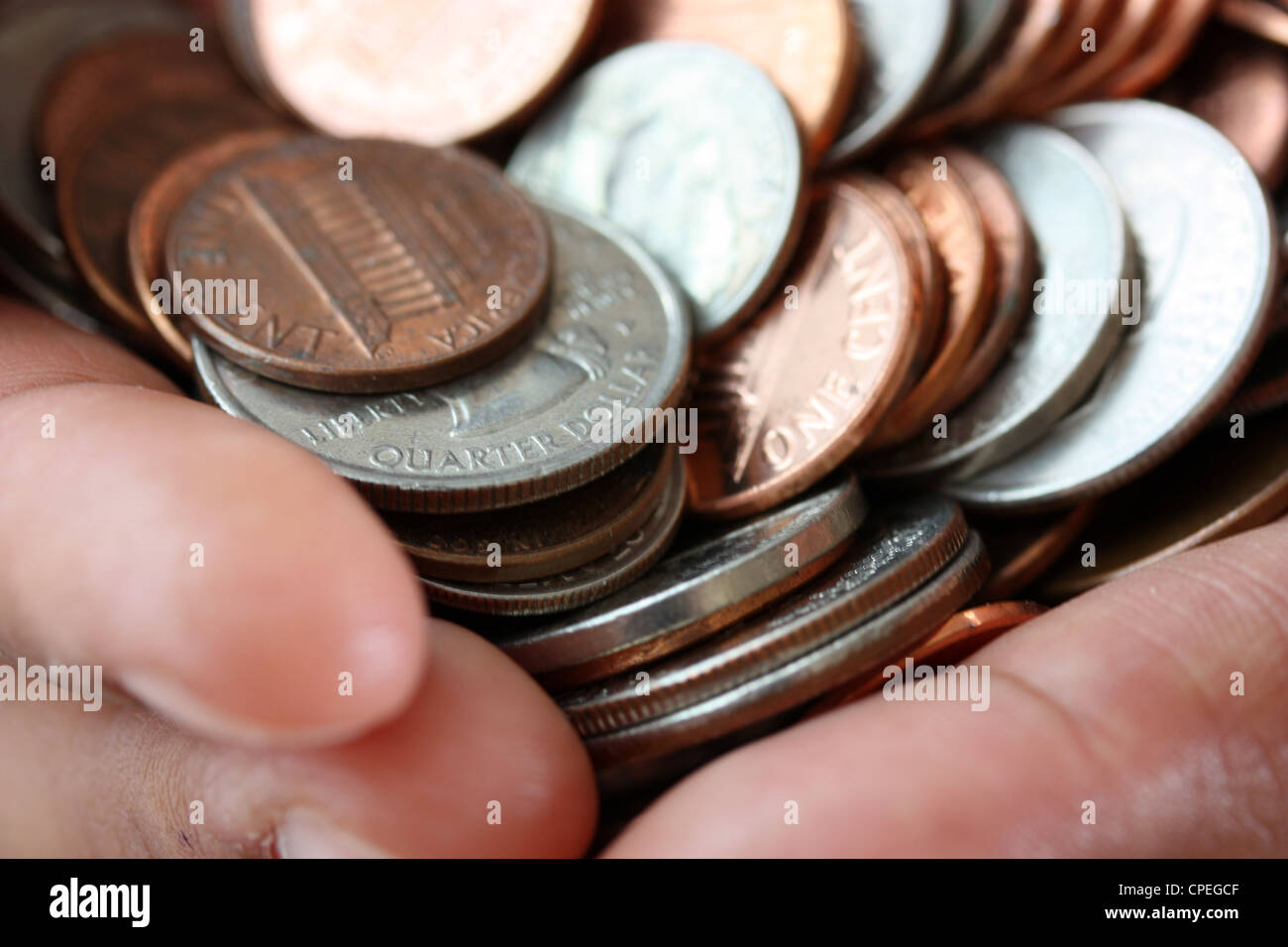 Haufen von Münzen in einer Womans Hand sitzen Stockfoto