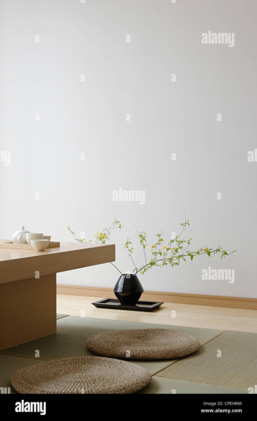 Tee-Set auf Tisch und Topfpflanze auf Tablett Stockfoto