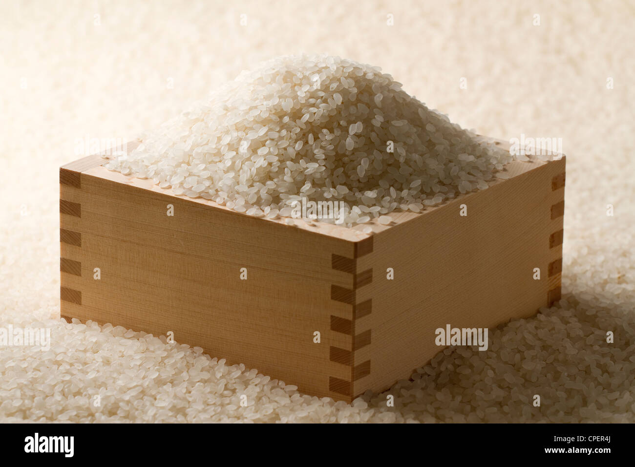 Holzkiste gefüllt und umgeben von Reis Stockfoto