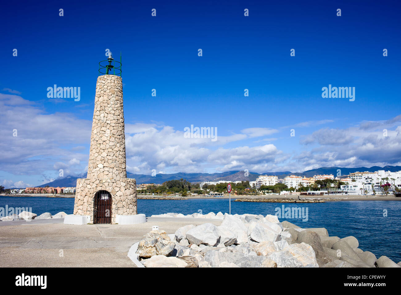 Stein-Leuchtturm am Ende der Mole in Puerto Banus in Spanien, südliche Andalusien, Provinz Malaga. Stockfoto