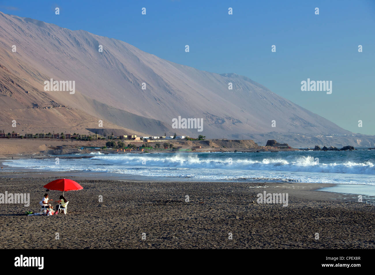 Roter Sonnenschirm am Strand Playa Huaiquique Iquique Chile Stockfoto