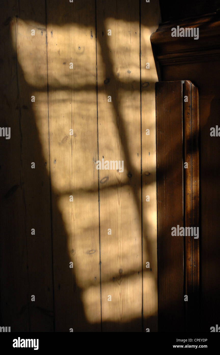 Licht aus einem Fenster reflektieren Wand, UK. Stockfoto