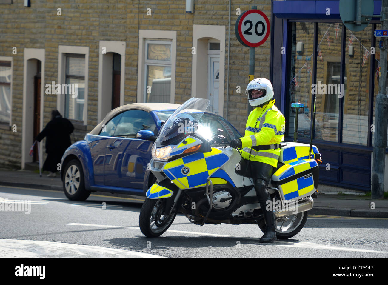 Polizei-Motorradfahrer stoppt Verkehr auf eine Mini-Kreisverkehr warten auf die Königin von England Autokolonne zu durchfahren. Stockfoto