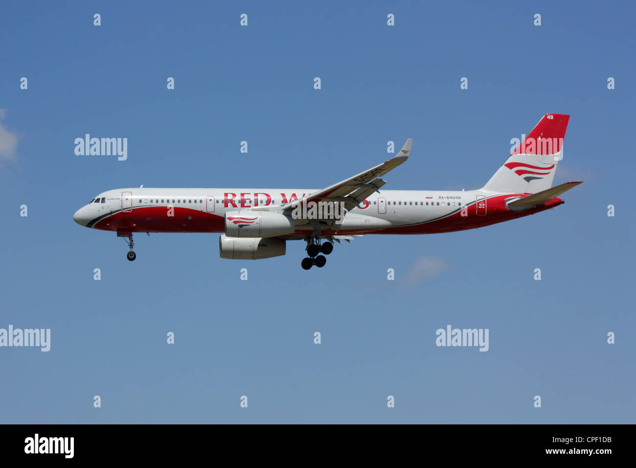 Red Wings Tupolew Tu-204-Verkehrsflugzeug am Ansatz vor blauem Himmel Stockfoto