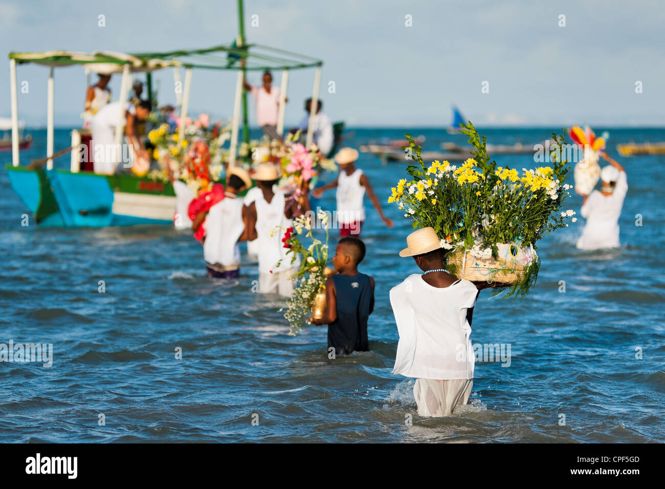 Candomblé-Anhänger tragen Blumenkörbe auf ein Boot während der rituellen Zeremonie zu Ehren Yemanjá in Amoreiras, Bahia, Brasilien. Stockfoto