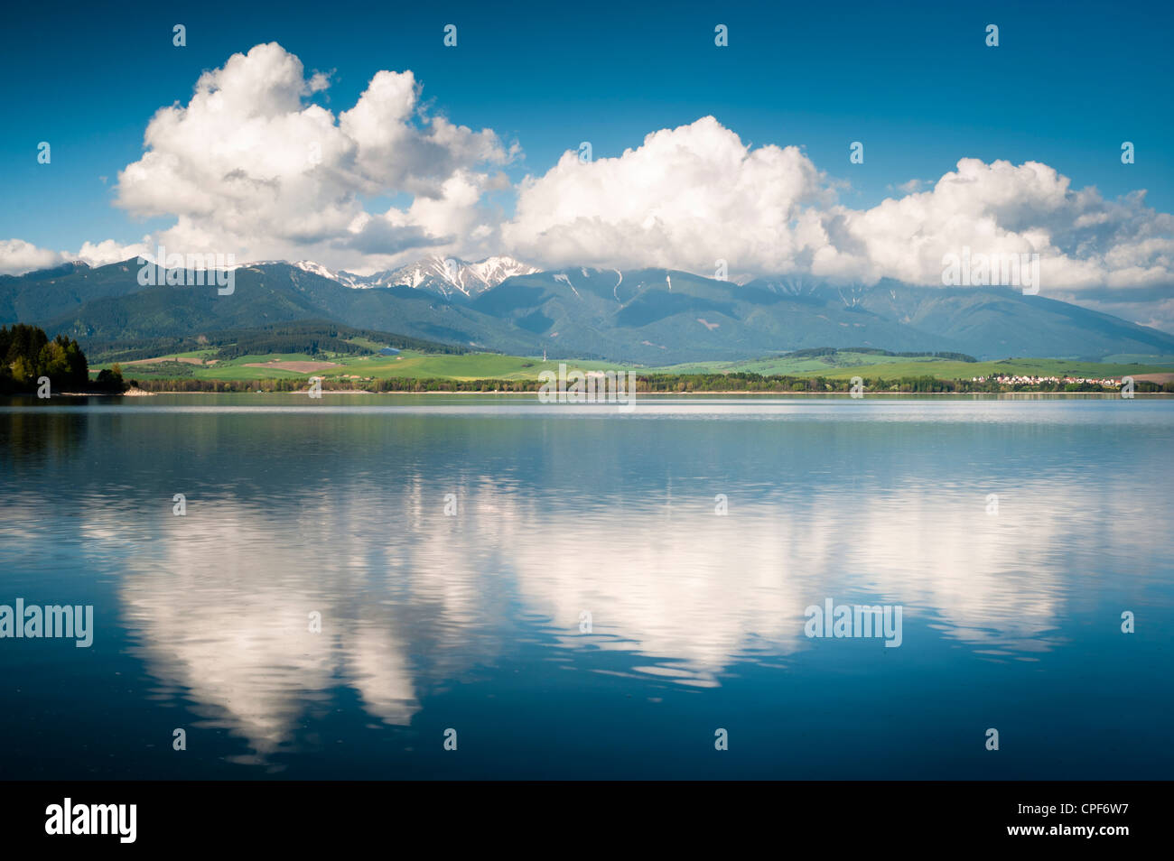Horizont mit Wolken und Berge und ihre Spiegelung im Wasser eines Sees Stockfoto