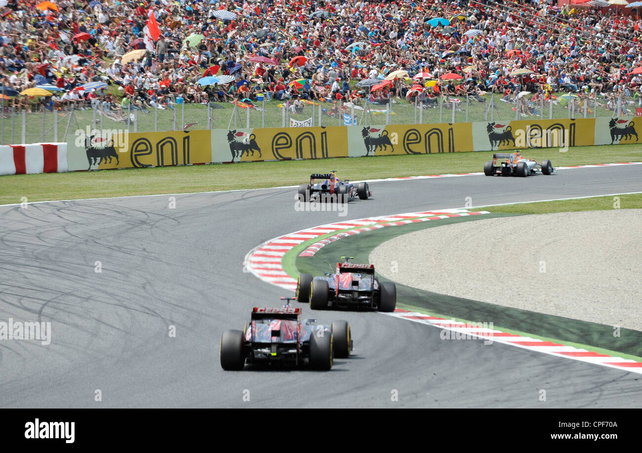 vier Rennautos passieren Kurve vor der Tribüne voll mit Zuschauern während der Formel 1 Grand Prix von Spanien 2012 Stockfoto