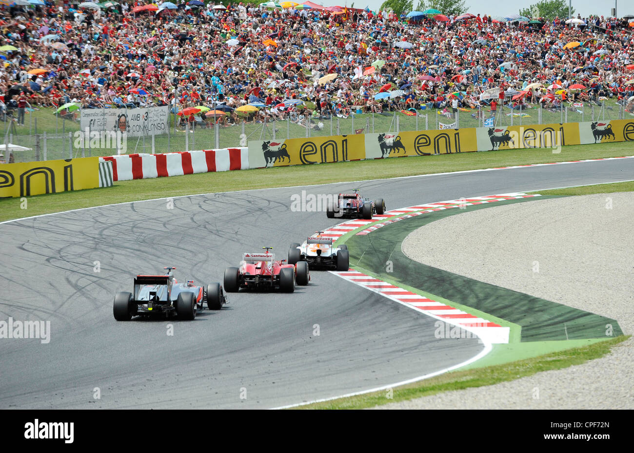 Vier Rennautos passieren Kurve vor der Tribüne voll mit Zuschauern während der Formel 1 Grand Prix von Spanien 2012 Stockfoto