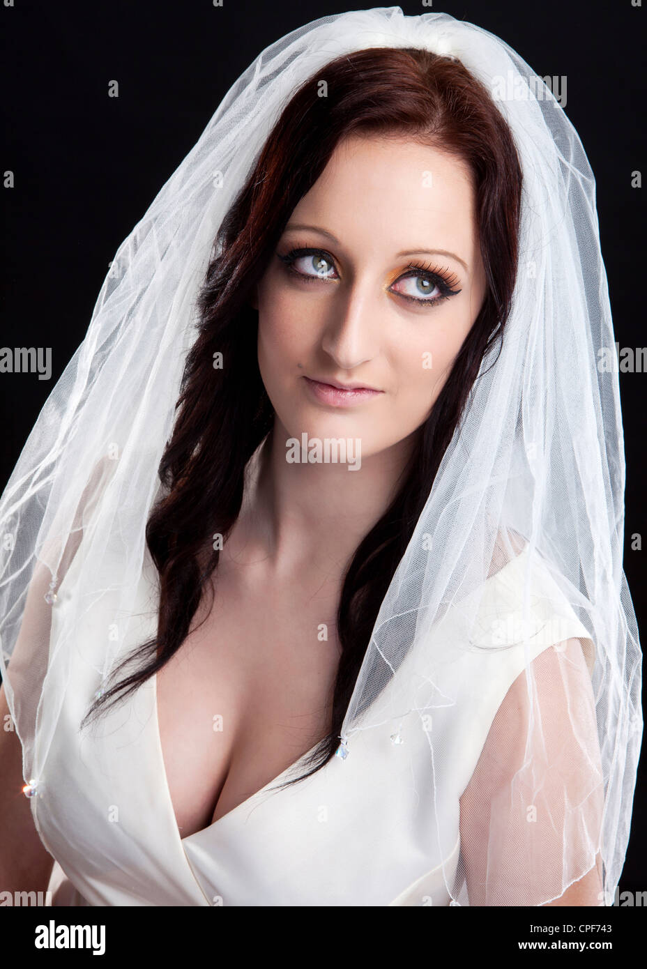 Halbe Länge Farbe Studio Portrait des weiblichen Modell tragen weiße Hochzeitskleid mit Schleier vor schwarzem Hintergrund fotografiert Stockfoto