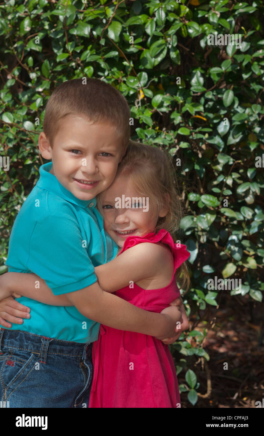 Sehr glücklich p [Ortrait Schwester Alter 3 und Bruder zu Hause 5 Jahre im Hof umarmt und Fürsorge füreinander Stockfoto