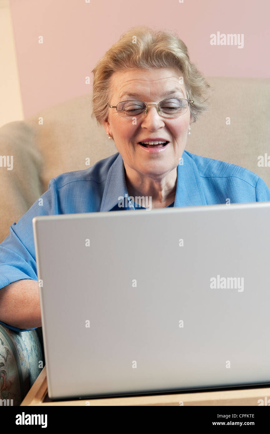Reife Frau mit Laptop und lächelnd Stockfoto