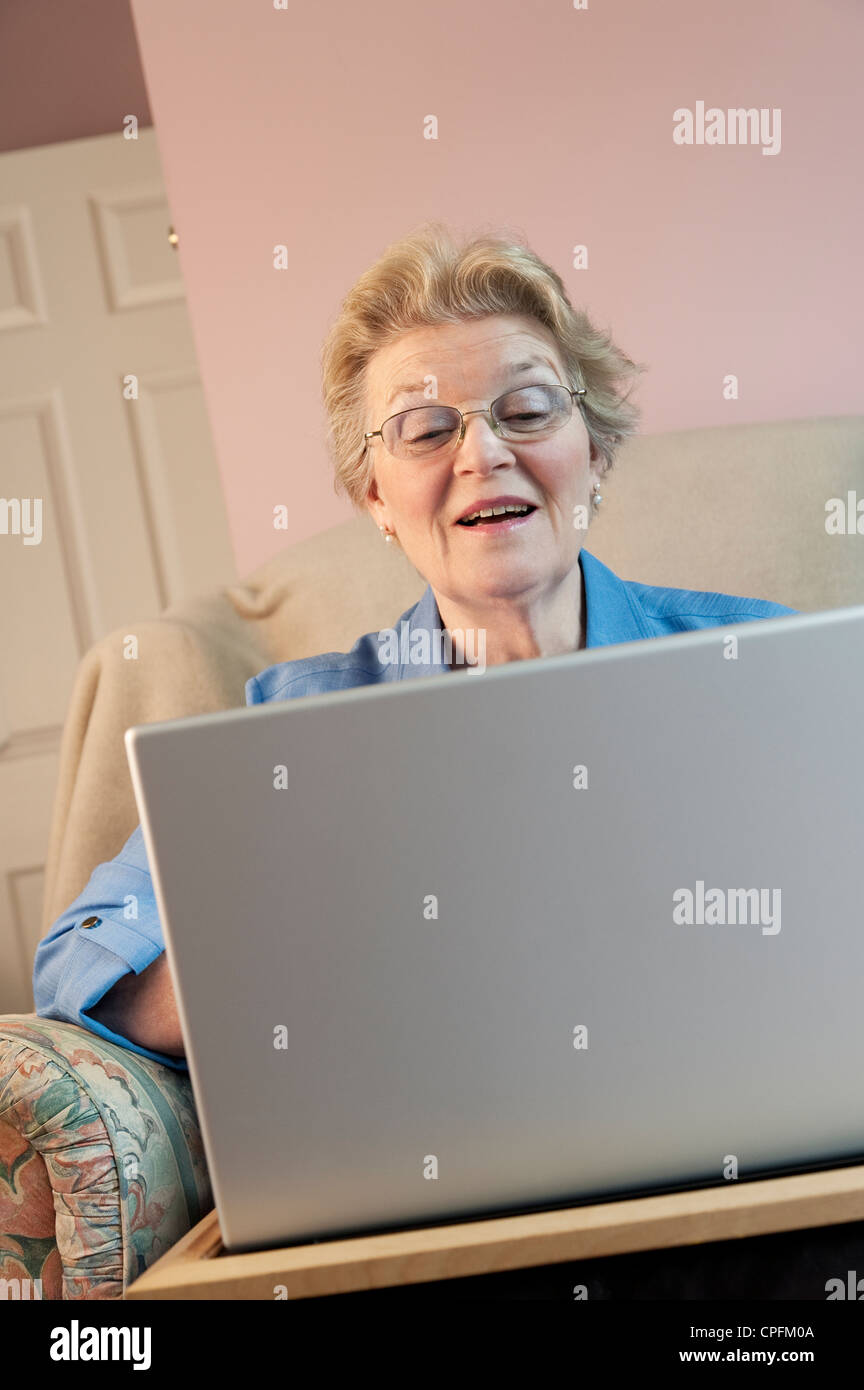 Reife Frau mit Laptop und lächelnd Stockfoto