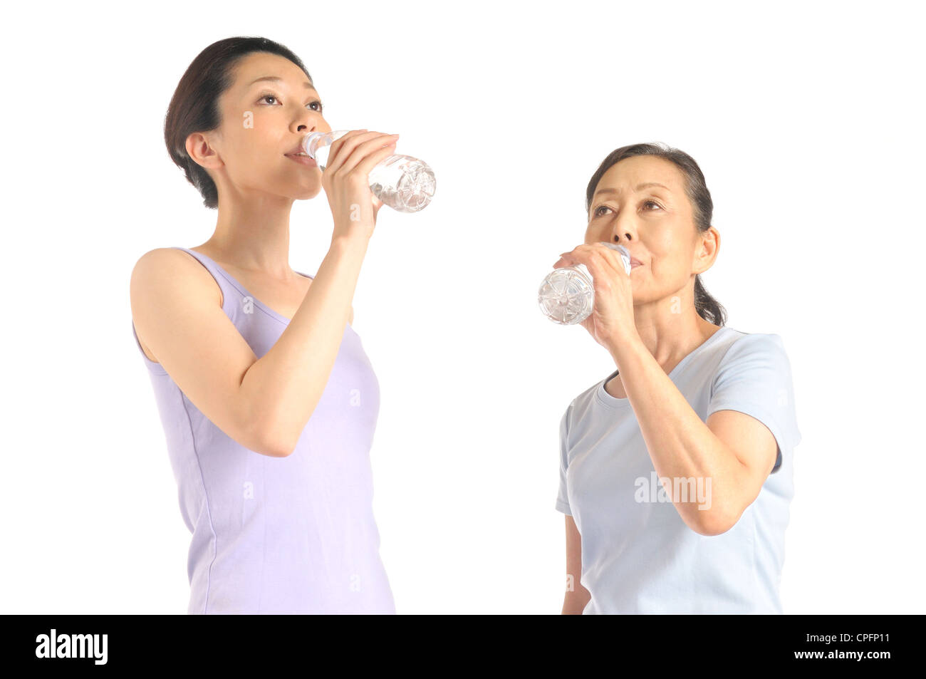 Ältere Frau und Mitte Erwachsene Frau trinken Wasser aus pet-Flasche Stockfoto