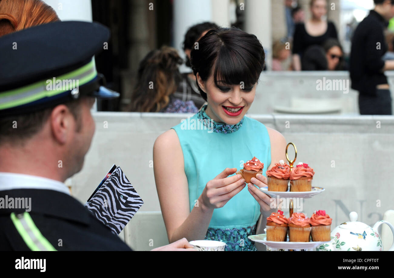 Attraktive Art und Weisemodell Essen einen Cupcake in Brighton Festival Tea Party 2012 ebenfalls Teil von Brighton Modewoche Stockfoto