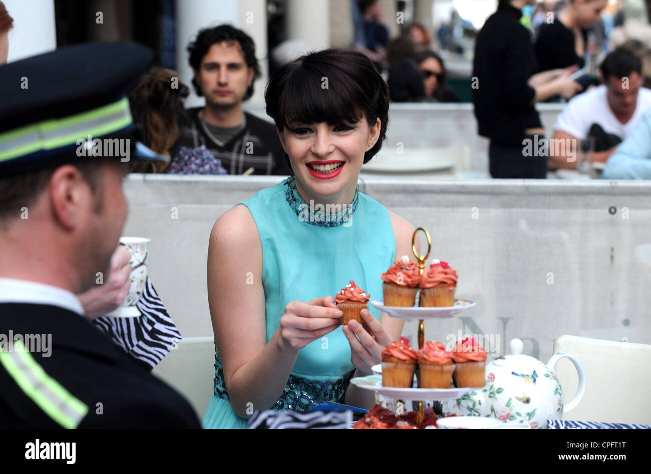 Attraktive Art und Weisemodell Essen einen Cupcake in Brighton Festival Tea Party auch Teil von Brighton Modewoche Stockfoto