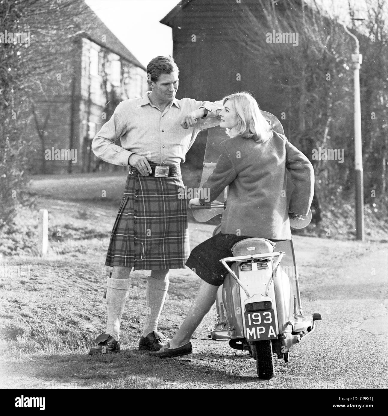Anzeige von sechziger Jahre Förderung der schottischen Zigaretten hergestellt. A ein Mann in einem Kilt erzählt mit einer jungen Frau, die auf ihrem Roller sitzt Stockfoto