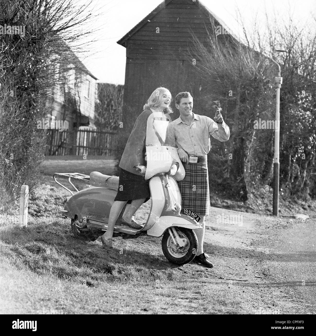 Anzeige von sechziger Jahre Förderung der schottischen gemachte Zigaretten zeigt einen Mann in einem Kilt mit einer jungen Frau auf einem Roller. Stockfoto