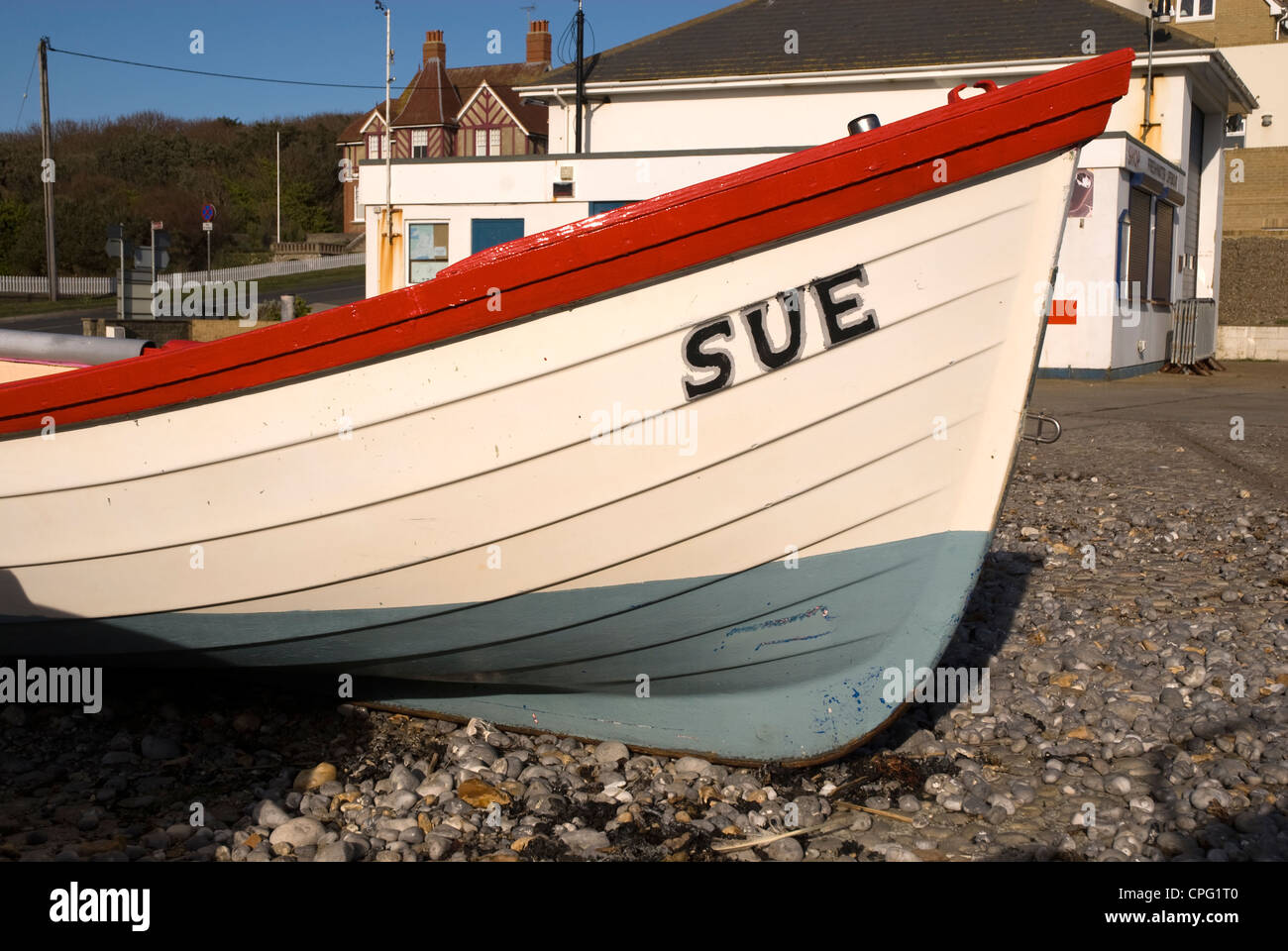 Ein kleines Ruderboot named SUE auf einem Kiesstrand Stockfoto