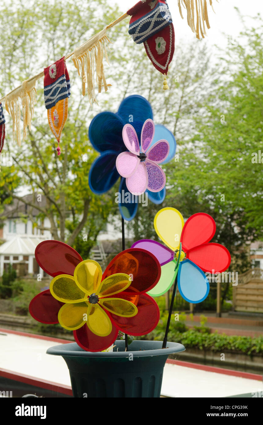 Öko-Windenergie: Plastikspielzeug Windmühlen in einem Blumentopf. Stockfoto