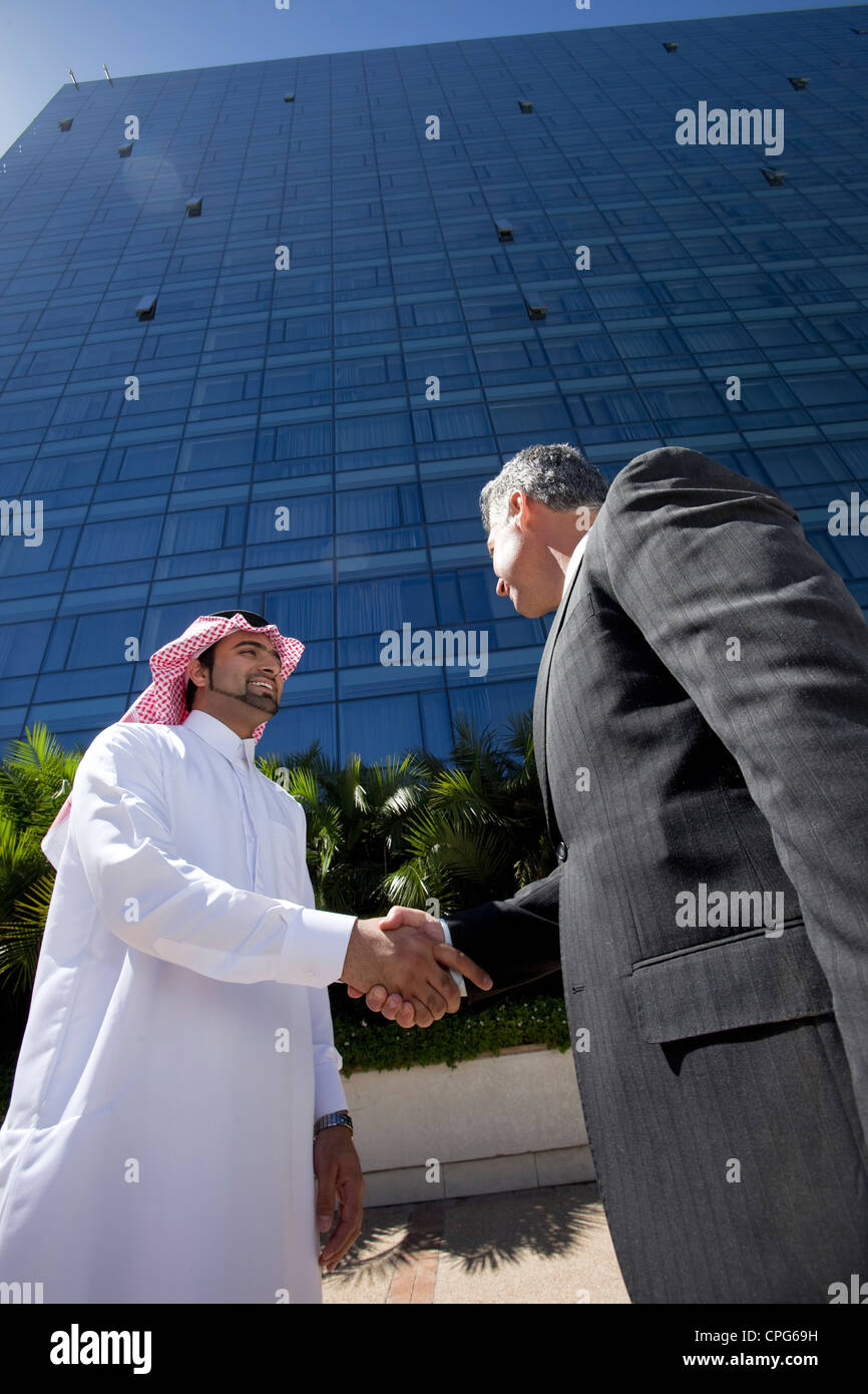 Arabische Geschäftsmann und westliche Geschäftsmann Händeschütteln vor der Bürogebäude. Stockfoto