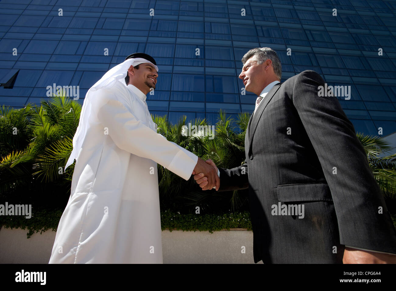 Arabische Geschäftsmann und westliche Geschäftsmann Händeschütteln vor der Bürogebäude. Stockfoto