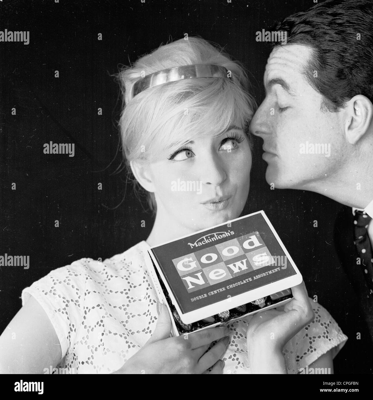 Paar immer enger. Frau gerne eine Schachtel Pralinen zu erhalten. 1960er Jahre Werbung noch für Mackintoshs Pralinen. Stockfoto