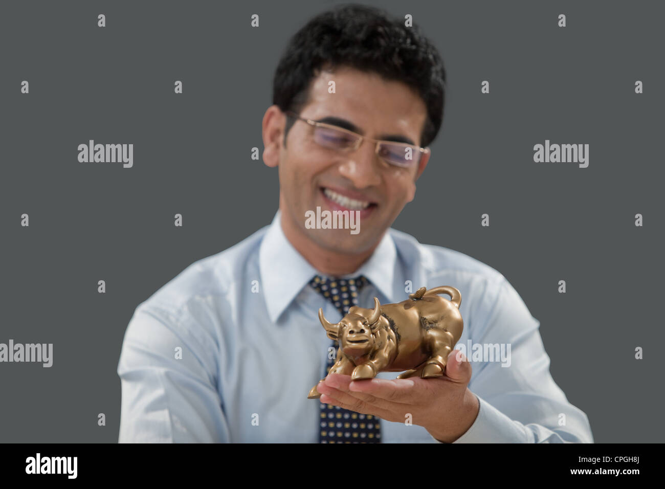 Mann, der eine Stier Figur hält Stockfoto