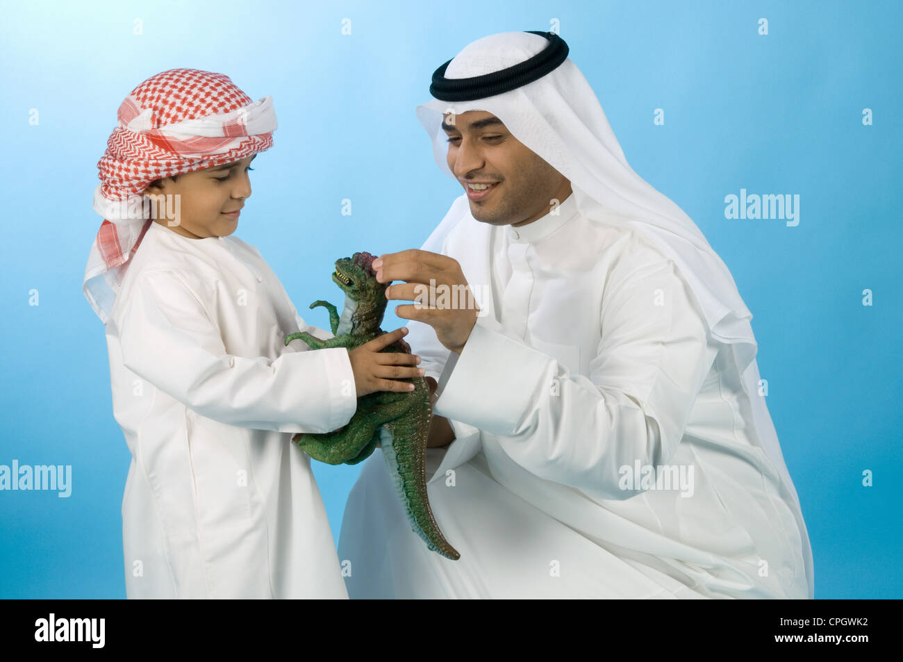 Arabische Jungen und Vater spielen mit Spielzeug Dinosaurier Stockfoto